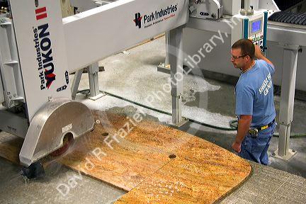 Worker custom cutting a granite countertop at the Shaker Hill Granite Company located in the town of Enfield, New Hampshire, USA.