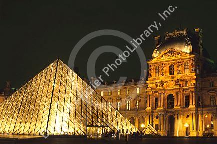 Glass pyramid at night at the entrance to the Lourve in Paris, France.