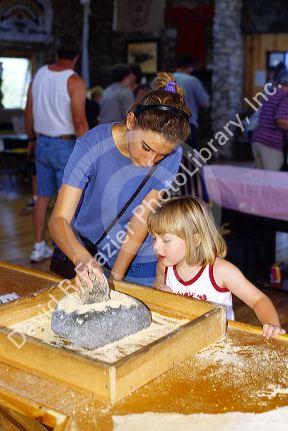 Mother and daughter using a mortar and pestle in the Indian Museum of North America at the Crazy Horse Memorial in the Black Hills of South Dakota.