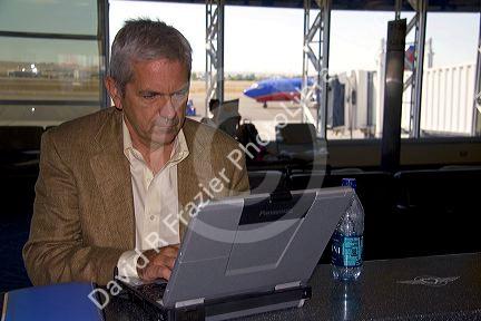 Man using a laptop computer in the Boise Airport, Boise, Idaho. MR