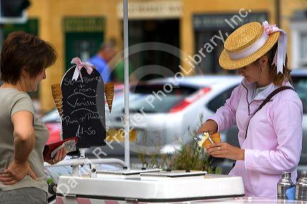 Female street vendor selling ice cream in the town of Moreton-in-Marsh, Gloucestershire, England.