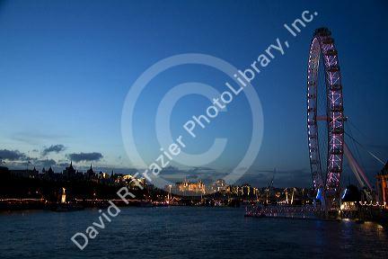 The London Eye at night along the River Thames in London, England.