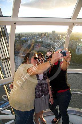 Tourists take their photo on the London Eye in the city of London, England.