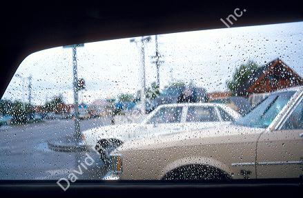 Water drops form on car window during rain storm.