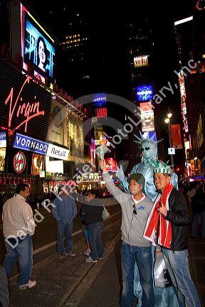 Tourists in Times Square at night in Manhattan, New York City, New York, USA.