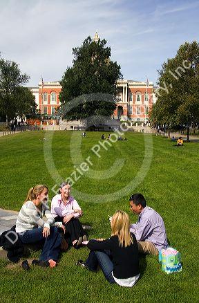 People socialize on Boston Common in front of the Massachusetts State House located in the Beacon Hill neighborhood of Boston, Massachusetts, USA.