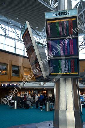 Airline departure notice board at the Portland International Airport in Portland, Oregon, USA.