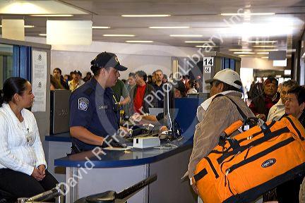 Pedestrians show identification and have their possesions searched to enter the United States port of entry at the Tijuana, Baja California, Mexico/San Diego, California border crossing.