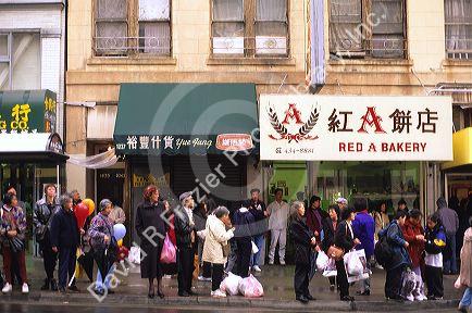 People wait in line for a bus in Chinatown, San Francisco, California.
