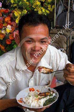 Vietnamese man eating lunch in the Cholon district of Ho Chi Minh City, Vietnam.