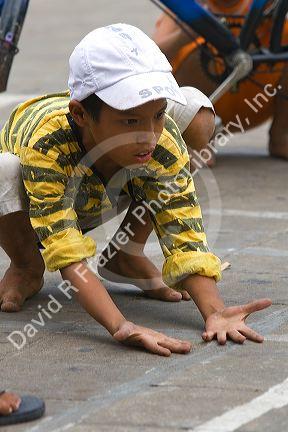 Vietnamese boy playing games on the street in Ho Chi Minh City, Vietnam.