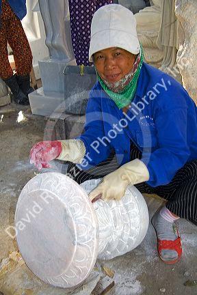 Vietnamese woman carving marble sculptures at a shop in Ngu Hanh Son ward south of Da Nang, Vietnam.