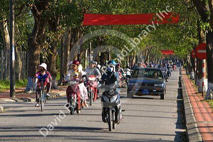 People ride motorbikes along the Imperial Citadel of Hue, Vietnam.