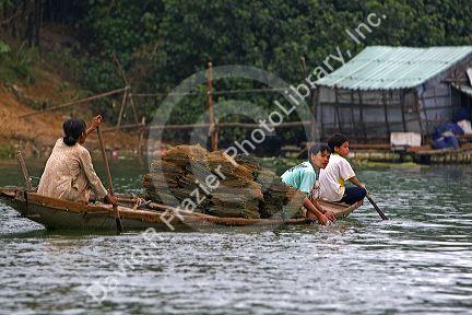 Vietnamese people transporting fishing nets by boat on the Perfume River at Hue, Vietnam.