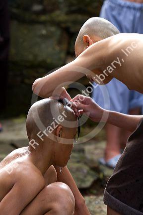 Novice Buddhist monks shave each other's heads at the Thien Mu Pagoda along the Perfume River in Hue, Vietnam.