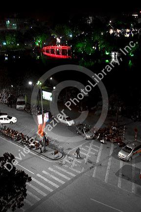 Night street scene with the Nuc Bridge and Hoan Kiem Lake in the historical center of Hanoi, Vietnam.