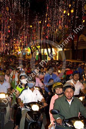 Vietnamese people ride motorbikes on Dong Khoi street during the last night of Tet Lunar New Year celebrations in Ho Chi Minh City, Vietnam.