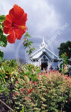 St. Benedicts painted church exterior in Hawaii with hibiscus flower.