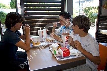 French teenage boys eat at a McDonalds fast food restaurant in Southern France.