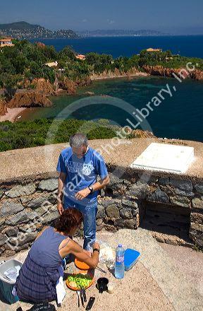 Couple having a picnic lunch overlooking the Mediterranean Sea near Frejus in Southern France.