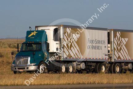 Transport truck hauling double refrigerated containers along Interstate 84 near Boise, Idaho, USA.