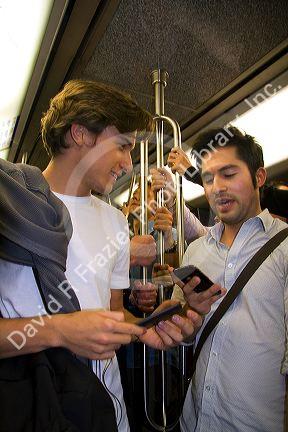 Passengers using electronic devices while riding on the Paris Metro in Paris, France.