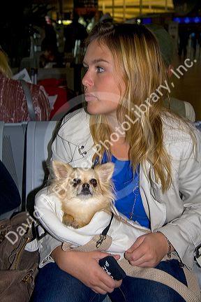 Woman traveling with a small dog in the Paris-Charles de Gaulle Airport, Paris, France.
