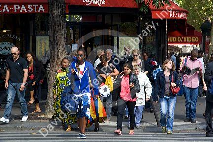 Pedestrians crossing the street in Paris, France.