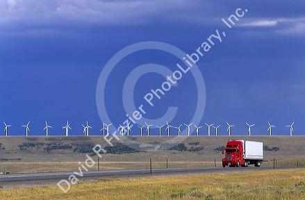A truck traveling on the highway with a row of windmills in the background in Arlington, Wyoming.