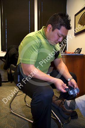 Law enforcement agent attaching an ankle monitor to a criminal under house arrest.
