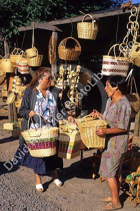 Vendor selling straw, mimbre baskets in Chimbarongo, Chile.