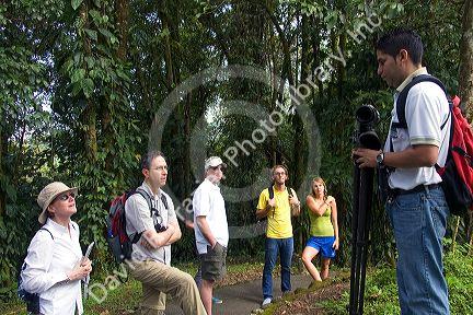 Naturalist guide talking to a group of birdwatchers in the Arenal Volcano National Park near La Fortuna, San Carlos, Costa Rica.