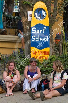 Female travelers sit in front of a surf school in the town of Tamarindo on the Northern Pacific Coast of Costa Rica.