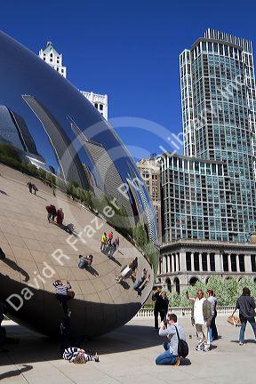 Visitors look at their reflection in the Cloud Gate public sculpture located at the AT&T Plaza in Millennium Park, Chicago, Illinois.