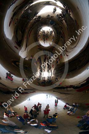 Visitors look at their reflection in the Cloud Gate public sculpture located at the AT&T Plaza in Millennium Park, Chicago, Illinois.