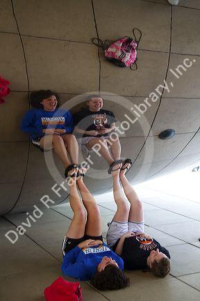 Visitors look at their reflection in the Cloud Gate public sculpture located at the AT&T Plaza in Millennium Park, Chicago, Illinois.