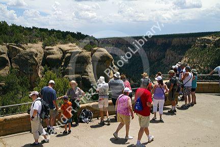 Tourists view cliff dwellings at Mesa Verde National Park located in Montezuma County, Colorado, USA.