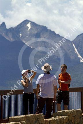 Tourists view the Rocky Mountains from a scenic overlook in the Rocky Mountain National Park, Colorado, USA.