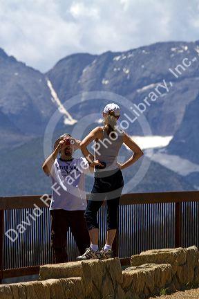 Tourists view the Rocky Mountains from a scenic overlook in the Rocky Mountain National Park, Colorado, USA.