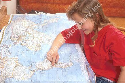 Young girl reading a map of he world.