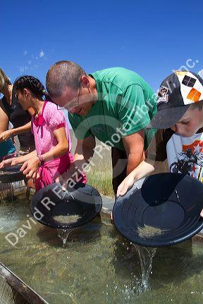 Visitors pan for gold in a demonstration gold panning sluice at the National Historic Oregon Trail Interpretive Center near Baker City, Oregon, USA.