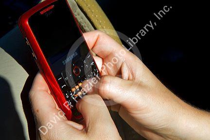 Text messaging on a cell phone while driving in Idaho, USA. MR