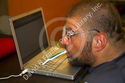 Quadriplegic Argentine man using a computer by typing with his mouth in Buenos Aires, Argentina.