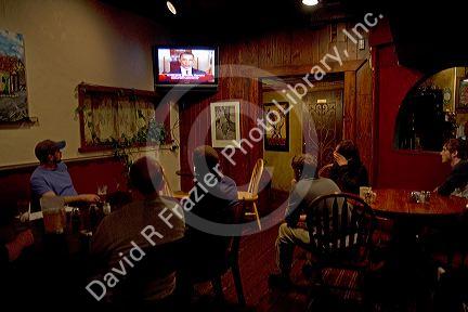 People watch President Obama on the television announcing the death of Osama Bin Laden at a restaurant in Boise, Idaho, USA.