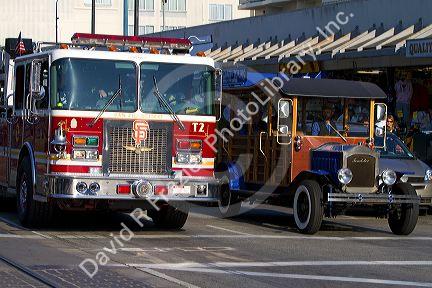 San Francisco Fire Department ladder truck and a vintage Packard tour vehicle driving in San Francisco, California, USA.