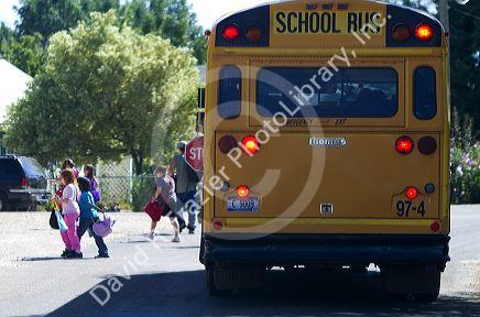 School bus stop with children crossing the street in Notus, Idaho, USA.