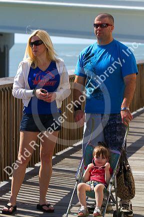 Family on the boardwalk at Johns Pass Village located on the waterfront at Madeira Beach, Florida, USA.