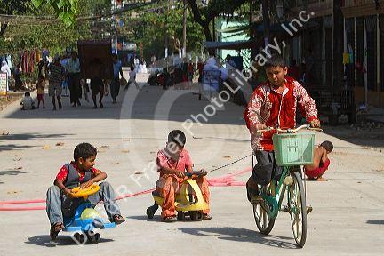 Children riding bicycles on the street in (Rangoon) Yangon, (Burma) Myanmar.