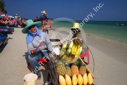 Vendors selling fruit at Chaweng beach and the Gulf of Thailand on the island of Ko Samui, Thailand.