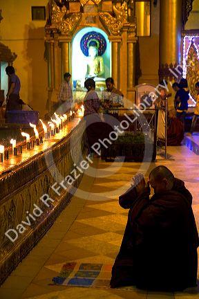Buddhist monk praying at the Shwedagon Paya located in (Rangoon)Yangon, (Burma) Myanmar.
